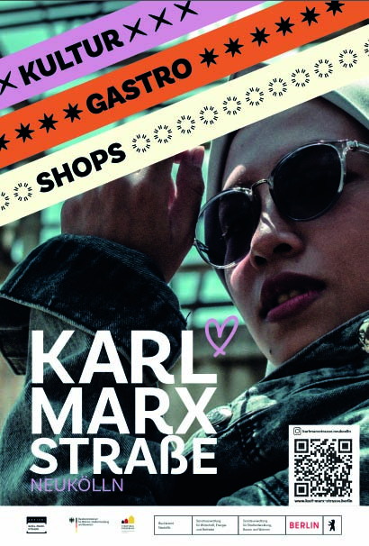 Junge Frau mit Sonnenbrille und Kopftuch die für Angebote auf der Karl-Marx-Straße wirbt